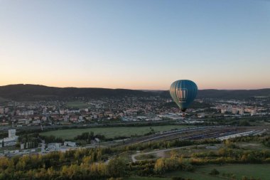 Sıcak hava balonu Beroun şehir kırsalında alçaktan uçuyor, manzaranın havadan manzarasını sunuyor..
