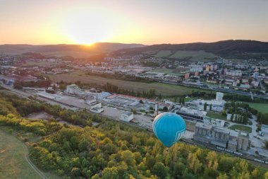 Sıcak hava balonu Beroun şehir kırsalında alçaktan uçuyor, manzaranın havadan manzarasını sunuyor..