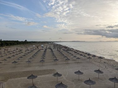 Arnavutluk kıyı şeridi boyunca uzanan mavi deniz ve kumlu plajlar üzerinde yamaç paraşütü manzarası, kıyı manzarası, turizm ve açık hava sporları faaliyetlerini yakalıyor
