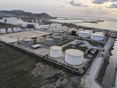 Petrol ürünleri ve gaz için depolama tanklarının yer aldığı bir petrol rafinerisinin hava manzarası, sanayi altyapısını gösteriyor.