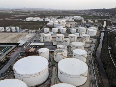 Petrol ürünleri ve gaz için depolama tanklarının yer aldığı bir petrol rafinerisinin hava manzarası, sanayi altyapısını gösteriyor.