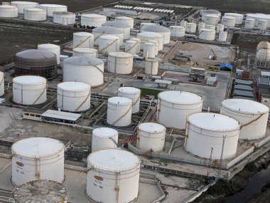 Petrol ürünleri ve gaz için depolama tanklarının yer aldığı bir petrol rafinerisinin hava manzarası, sanayi altyapısını gösteriyor.