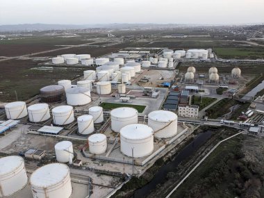 Petrol ürünleri ve gaz için depolama tanklarının yer aldığı bir petrol rafinerisinin hava manzarası, sanayi altyapısını gösteriyor.