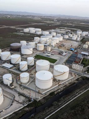 Petrol ürünleri ve gaz için depolama tanklarının yer aldığı bir petrol rafinerisinin hava manzarası, sanayi altyapısını gösteriyor.