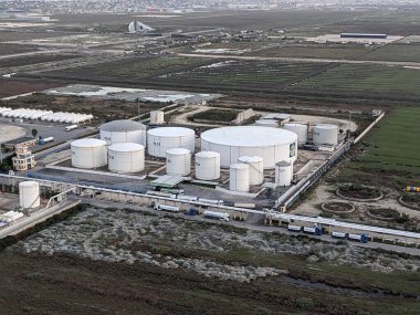 Petrol ürünleri ve gaz için depolama tanklarının yer aldığı bir petrol rafinerisinin hava manzarası, sanayi altyapısını gösteriyor.