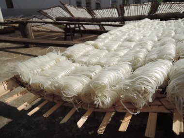 Güneydoğu Asya 'da geleneksel pirinç eriştesi üretimi, vietnam, pirinç unundan elde yapılan erişte, bambu yapımları, lezzetli yerel yiyecekler, sokakta güneşte kurutulmaktan daha iyidir.