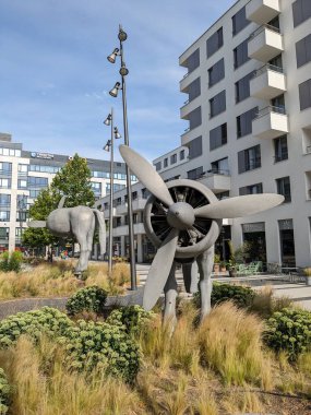 PRAGUE, CZECH REPUBLIC - 29 Temmuz 2023: İş ofisleri binaları ve üzerinde dönen pervaneli at heykelleri olan park eski Waltrovka fabrikası, Çek Cumhuriyeti 'ndeki Jinonice-Prag gayrimenkulleri