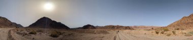 Ürdün 'deki Wadi Rum çölünün panoramik manzarası. Dağlar ve kayaların oluşturduğu düz kum üzerinde hareket eden bulutlar. Yeryüzünün güzelliğini keşfedin. Ulusal park manzarası. UNESCO