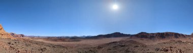 Ürdün 'deki Wadi Rum çölünün panoramik manzarası. Dağlar ve kayaların oluşturduğu düz kum üzerinde hareket eden bulutlar. Yeryüzünün güzelliğini keşfedin. Ulusal park manzarası. UNESCO