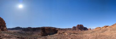 Ürdün 'deki Wadi Rum çölünün panoramik manzarası. Dağlar ve kayaların oluşturduğu düz kum üzerinde hareket eden bulutlar. Yeryüzünün güzelliğini keşfedin. Ulusal park manzarası. UNESCO