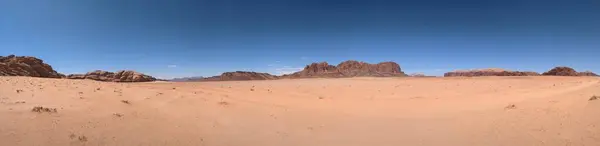 Panoramic view of Wadi Rum desert in Jordan with clouds moving over flat sand landscape with mountains and rocks formations.Discover beauty of the earth. National park outdoors landscape.UNESCO