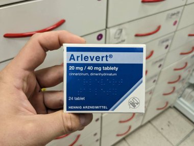 Prague, Czech Republic - July 10 2024: ARLEVERT box of medication with CINNARIZINE and DIMENHYDRINATE active substances by HENNIG ARZNEIMITTEL, used for treatment of vertigo and motion sickness. clipart