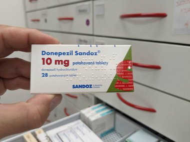 Prague, Czech Republic - July 10 2024: DONEPEZIL SANDOZ box of medication with DONEPEZIL active substance by SANDOZ, used for treatment of Alzheimer's disease and dementia. clipart