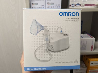 Prag, Çek Cumhuriyeti-9 Ekim 2024: OMRON C101 ESSENTIAL INHALATOR, solunum hastalıklarının etkili bir şekilde tedavi edilmesi ve akciğerlere ilaç verilmesi için tasarlanmış kompakt bir nebulizatördür.