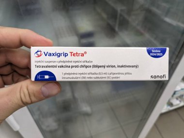 Prag, Çek Cumhuriyeti - 14 Ekim 2023: Eczane kavramı-Vaxigrip tetra aşı paketi bir buzdolabı eczacısının elinin önünde. Bu aşı sizi veya çocuğunuzu gribe karşı korumaya yardımcı olur (grip).)