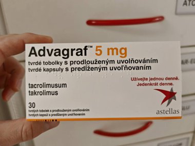 Prague, Czech Republic - August 28 2024: ADVAGRAF box with TACROLIMUS active substance by ASTELLAS, used for prevention of organ transplant rejection. clipart