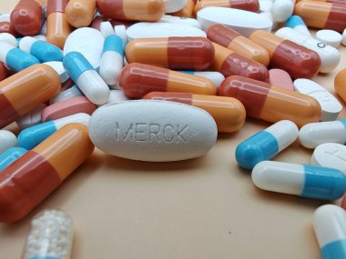 Eczacılık görsel kapsüllerindeki renkli kapsüllerin ve tabletlerin üzerine MerCK damgalı beyaz hap.