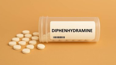 Diphenhydramine plastik ilaç kutusu ve masada tabletler.