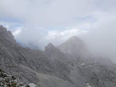 Sloven Alplerinin tepelerinin bulutlarla kaplı olduğu Logarska Dolina Vadisi 'nin panoramik manzarası.