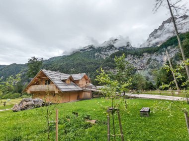 Slovenya 'daki Logar Vadisi' nde manzaralı dağlar, ahşap yerel kulübeler ve geleneksel alp çiftlikleri var..
