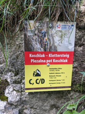 Avusturya Alpleri 'ndeki demir yolu üzerinden güvenli kaya yüzeyi üzerinden Koschlak Klettersteig' e tırmanan tırmanıcı.