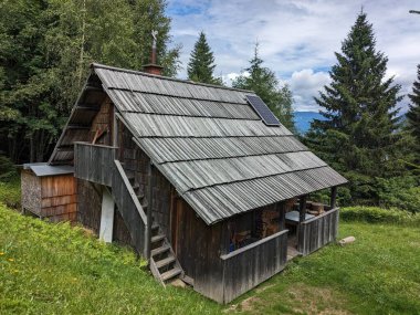 Slovenya 'daki Logar Vadisi' nde manzaralı dağlar, ahşap yerel kulübeler ve geleneksel alp çiftlikleri var..