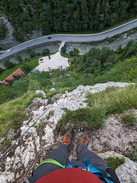 Avusturya Alpleri 'ndeki demir yolu üzerinden güvenli kaya yüzeyi üzerinden Koschlak Klettersteig' e tırmanan tırmanıcı.