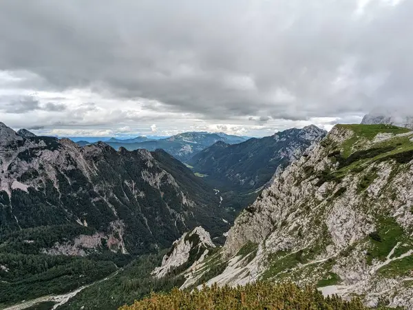 Sloven Alplerinin tepelerinin bulutlarla kaplı olduğu Logarska Dolina Vadisi 'nin panoramik manzarası.