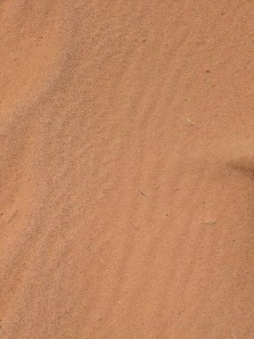 Turuncu renkli kum desenli arka plan. Wadi Rum Çölü, Ürdün, Arabistan manzaralı güzel manzara, çölde kırmızı portakallı kuma yakın çekim