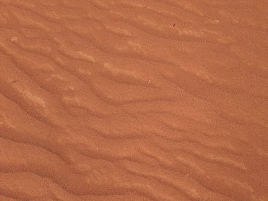 Turuncu renkli kum desenli arka plan. Wadi Rum Çölü, Ürdün, Arabistan manzaralı güzel manzara, çölde kırmızı portakallı kuma yakın çekim