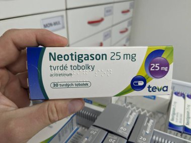 Prag, Çek Cumhuriyeti - 10 Temmuz 2024: TEVA tarafından ciddi sedef ve deri hastalıklarının tedavisinde kullanılan ACITRETIN aktif maddeyle birlikte NEOTIGASON TEVA ilaç kutusu.
