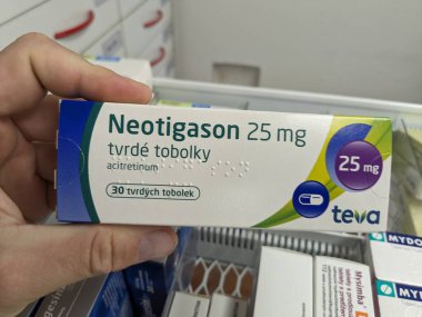 Prag, Çek Cumhuriyeti - 10 Temmuz 2024: TEVA tarafından ciddi sedef ve deri hastalıklarının tedavisinde kullanılan ACITRETIN aktif maddeyle birlikte NEOTIGASON TEVA ilaç kutusu.