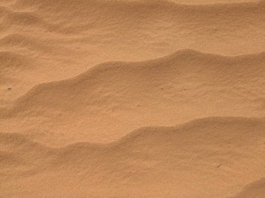 Turuncu renkli kum desenli arka plan. Wadi Rum Çölü, Ürdün, Arabistan manzaralı güzel manzara, çölde kırmızı portakallı kuma yakın çekim