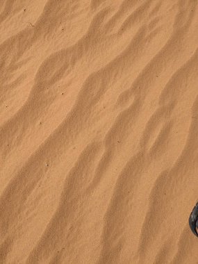 Turuncu renkli kum desenli arka plan. Wadi Rum Çölü, Ürdün, Arabistan manzaralı güzel manzara, çölde kırmızı portakallı kuma yakın çekim