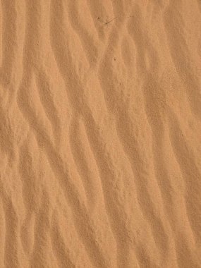 Turuncu renkli kum desenli arka plan. Wadi Rum Çölü, Ürdün, Arabistan manzaralı güzel manzara, çölde kırmızı portakallı kuma yakın çekim