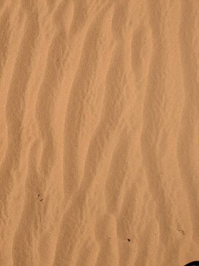 Turuncu renkli kum desenli arka plan. Wadi Rum Çölü, Ürdün, Arabistan manzaralı güzel manzara, çölde kırmızı portakallı kuma yakın çekim