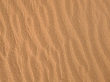 Turuncu renkli kum desenli arka plan. Wadi Rum Çölü, Ürdün, Arabistan manzaralı güzel manzara, çölde kırmızı portakallı kuma yakın çekim