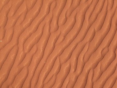 Turuncu renkli kum desenli arka plan. Wadi Rum Çölü, Ürdün, Arabistan manzaralı güzel manzara, çölde kırmızı portakallı kuma yakın çekim