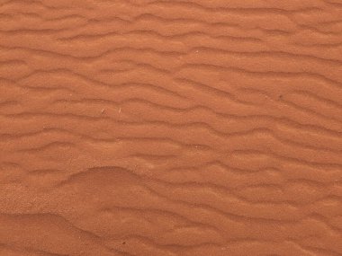 Turuncu renkli kum desenli arka plan. Wadi Rum Çölü, Ürdün, Arabistan manzaralı güzel manzara, çölde kırmızı portakallı kuma yakın çekim