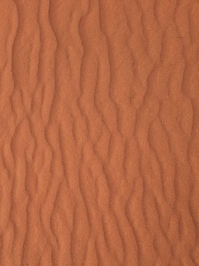Turuncu renkli kum desenli arka plan. Wadi Rum Çölü, Ürdün, Arabistan manzaralı güzel manzara, çölde kırmızı portakallı kuma yakın çekim