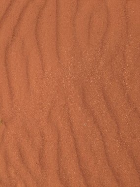 Turuncu renkli kum desenli arka plan. Wadi Rum Çölü, Ürdün, Arabistan manzaralı güzel manzara, çölde kırmızı portakallı kuma yakın çekim