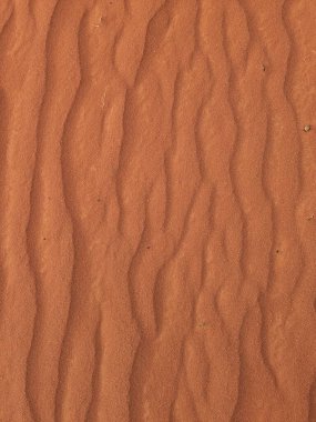 Turuncu renkli kum desenli arka plan. Wadi Rum Çölü, Ürdün, Arabistan manzaralı güzel manzara, çölde kırmızı portakallı kuma yakın çekim