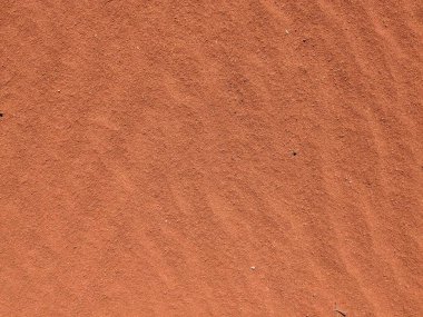 Turuncu renkli kum desenli arka plan. Wadi Rum Çölü, Ürdün, Arabistan manzaralı güzel manzara, çölde kırmızı portakallı kuma yakın çekim