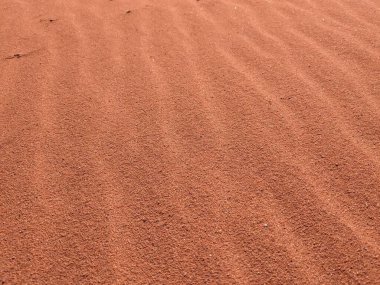 Turuncu renkli kum desenli arka plan. Wadi Rum Çölü, Ürdün, Arabistan manzaralı güzel manzara, çölde kırmızı portakallı kuma yakın çekim
