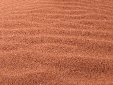 Turuncu renkli kum desenli arka plan. Wadi Rum Çölü, Ürdün, Arabistan manzaralı güzel manzara, çölde kırmızı portakallı kuma yakın çekim