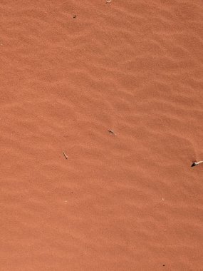 Turuncu renkli kum desenli arka plan. Wadi Rum Çölü, Ürdün, Arabistan manzaralı güzel manzara, çölde kırmızı portakallı kuma yakın çekim
