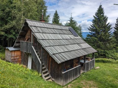 Slovenya 'daki Logar Vadisi' nde manzaralı dağlar, ahşap yerel kulübeler ve geleneksel alp çiftlikleri var..