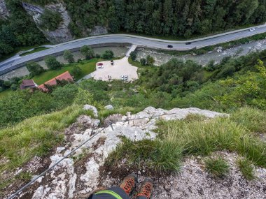 Avusturya Alpleri 'ndeki demir yolu üzerinden güvenli kaya yüzeyi üzerinden Koschlak Klettersteig' e tırmanan tırmanıcı.