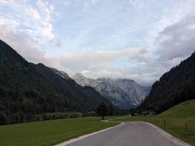Sloven Alplerinin tepelerinin bulutlarla kaplı olduğu Logarska Dolina Vadisi 'nin panoramik manzarası.