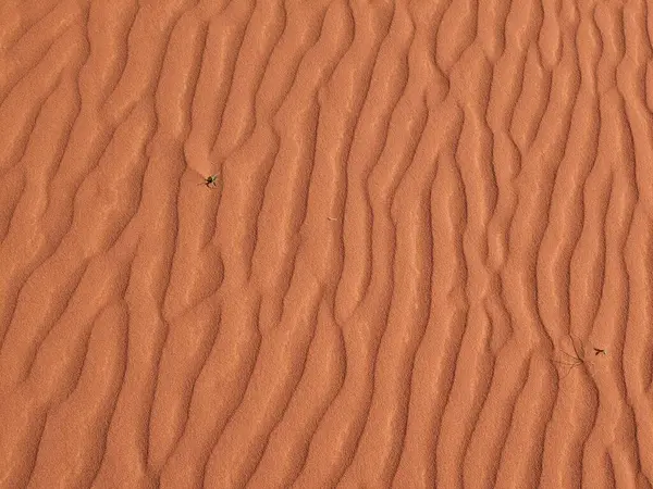 Turuncu renkli kum desenli arka plan. Wadi Rum Çölü, Ürdün, Arabistan manzaralı güzel manzara, çölde kırmızı portakallı kuma yakın çekim